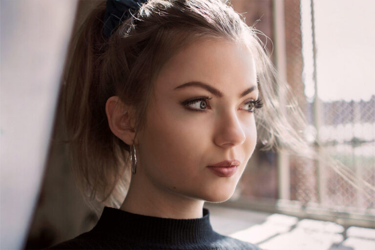 Close-up of a thoughtful woman with flawless skin and balanced features, reflecting on cosmetic surgery choices