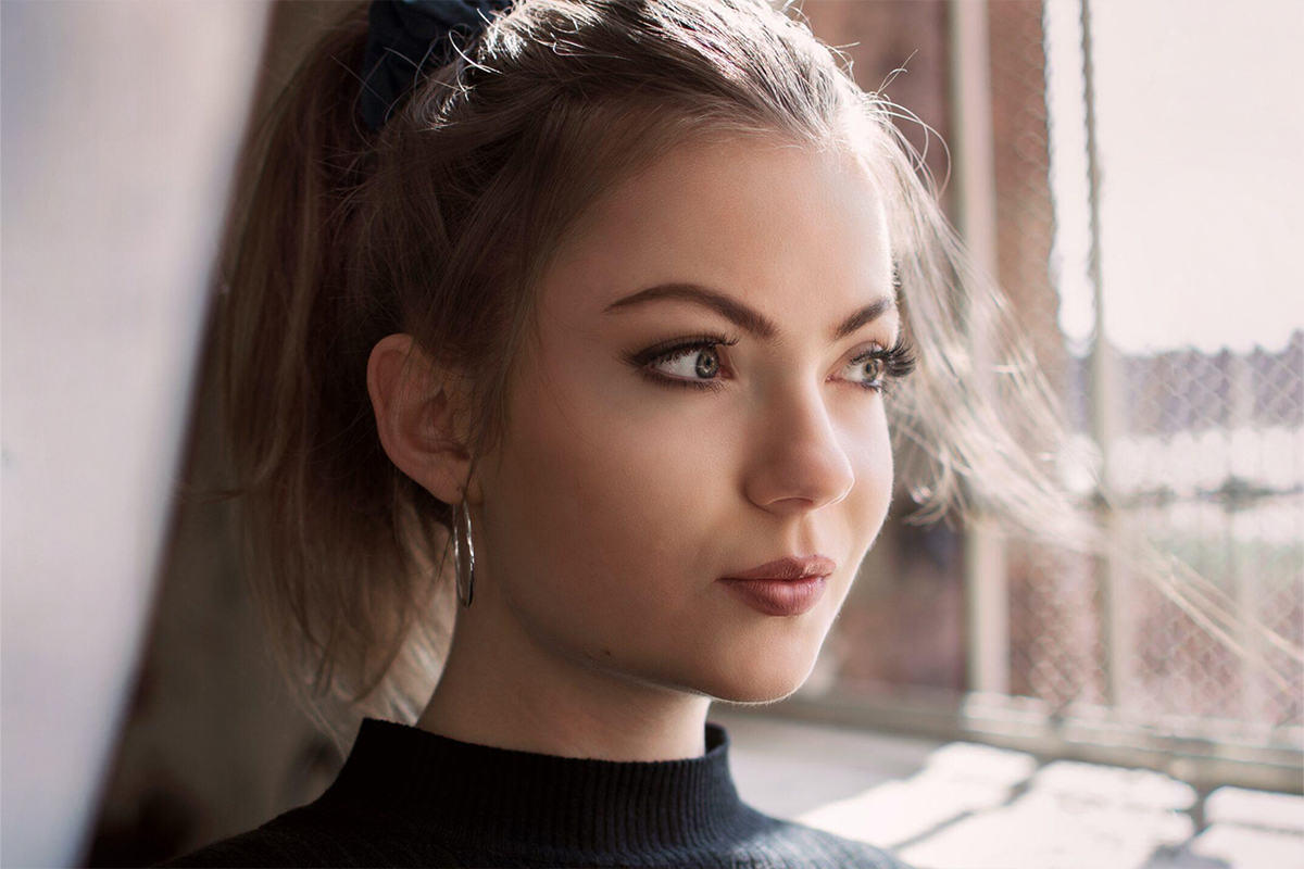 Close-up of a thoughtful woman with flawless skin and balanced features, reflecting on cosmetic surgery choices