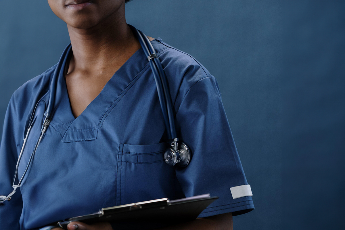 Medical professional in scrubs with stethoscope and clipboard, symbolizing trust, ethics, and board-certified care.