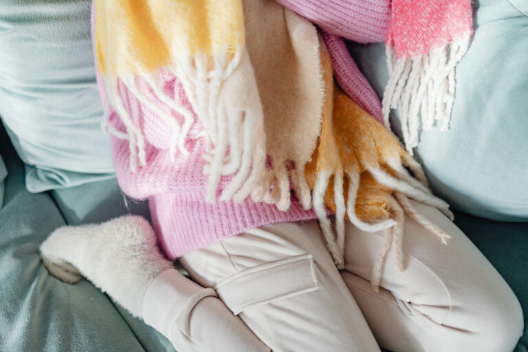 Person dressed in cozy pink sweater, scarf, and soft pants, showing ideal loose clothing choice for surgery day