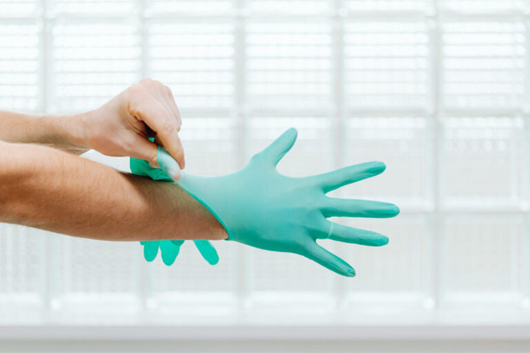 Close-up of a medical professional putting on teal surgical gloves, preparing for a popular facial cosmetic procedure.