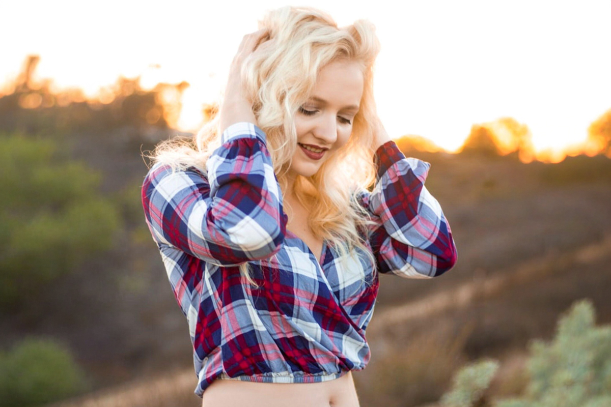 Smiling woman outdoors with midriff showing, representing liposuction results with minimal scarring