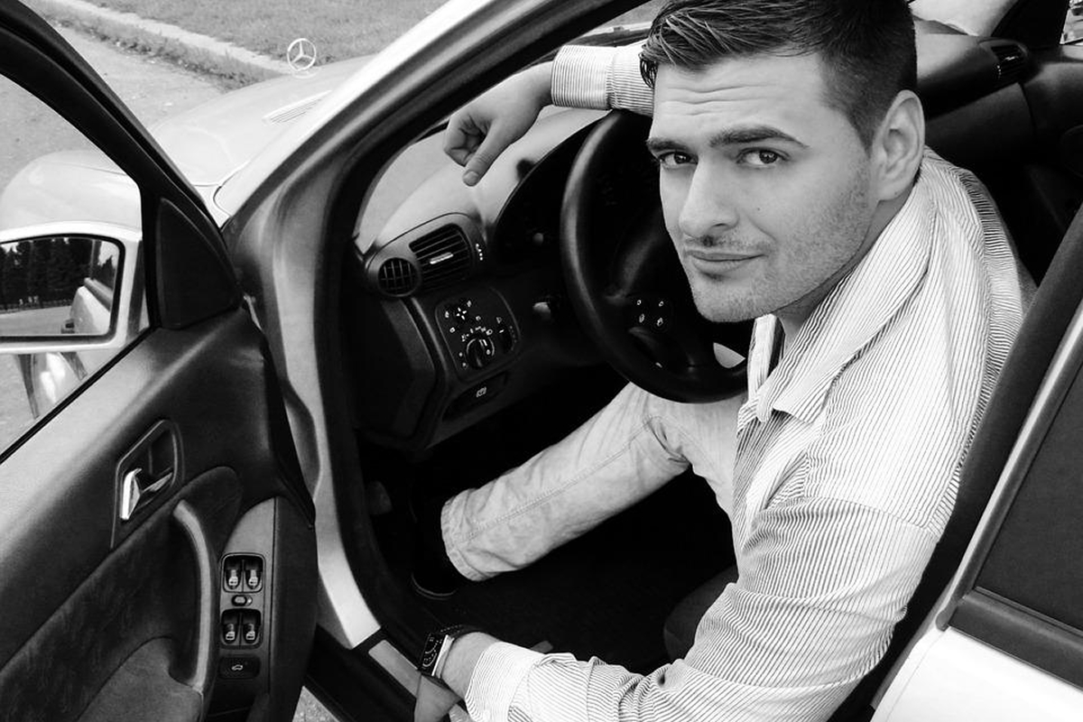 Man sitting in driver’s seat with car door open, representing the need to arrange transportation after a LASIK consultation due to eye dilation