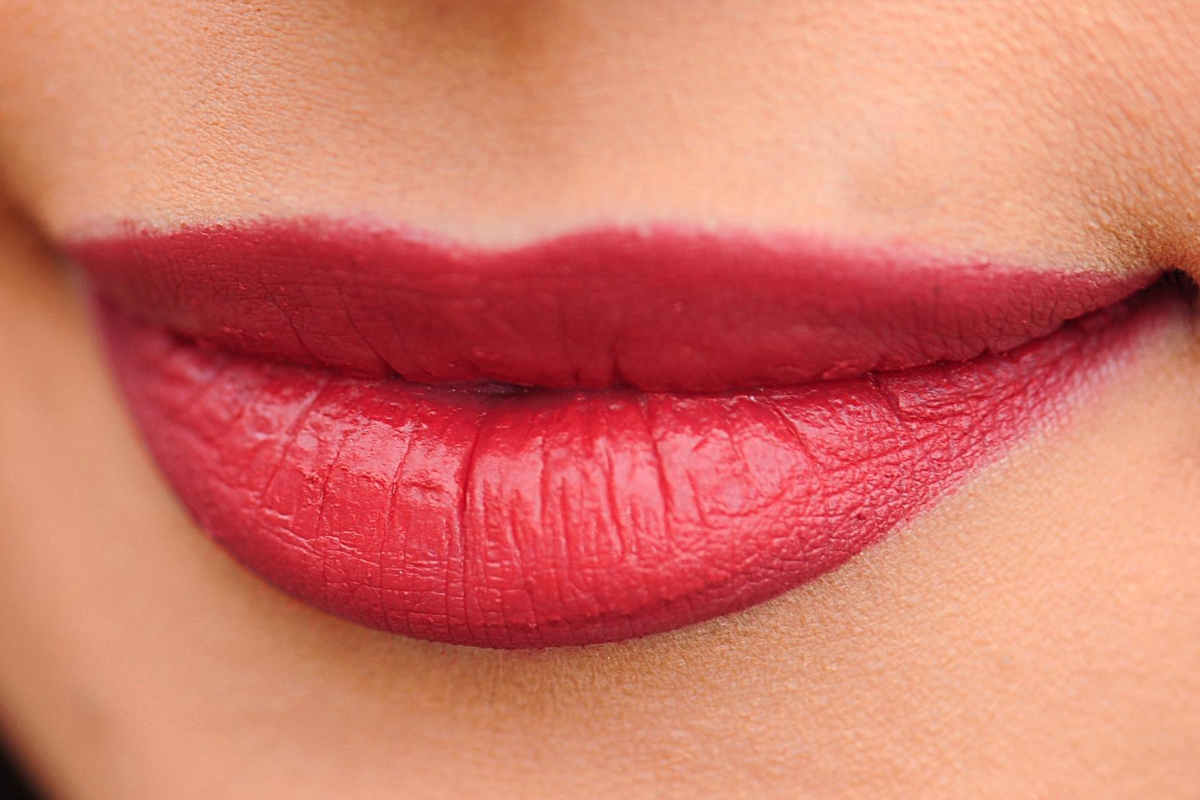 Closeup of red lips with smooth texture, showing enhanced volume from hyaluronic acid lip injections