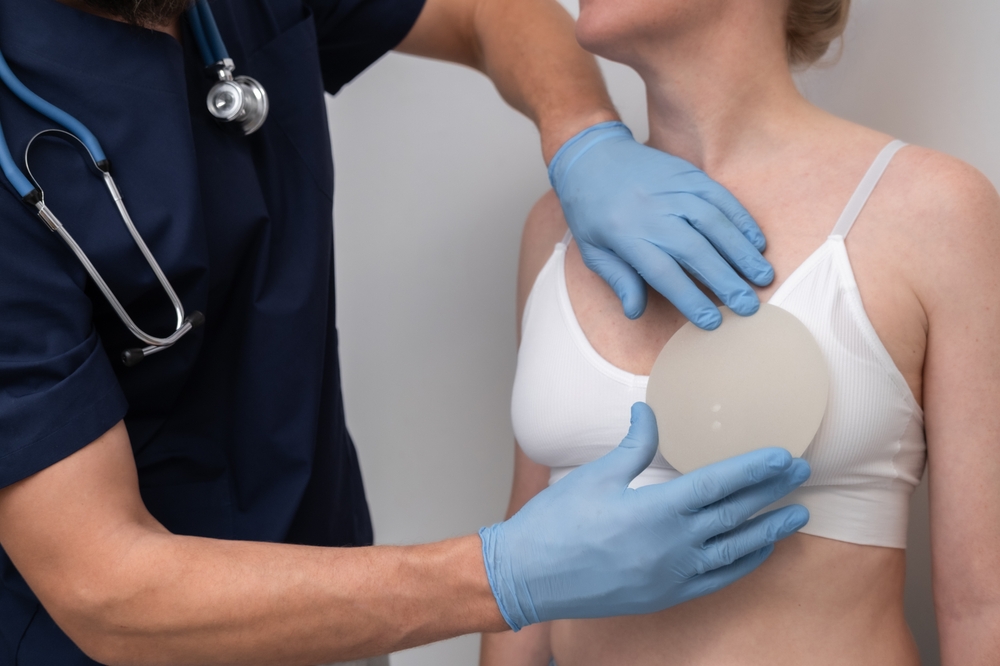 Surgeon evaluating breast implant size during consultation to enhance breast shape, contour, and upper body proportions.
